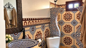 A bathroom with a large mirror, a bowl sink, a toilet, and patterned tiles. - auberge tissadrine (Drâa-Tafilalet)