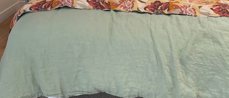 Une chambre à coucher comprenant un lit, une table de chevet, une lampe et un luminaire fixé au mur.