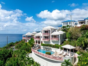 Un complex turístic de diversos pisos, amb piscina, balcons i vistes a l'oceà.