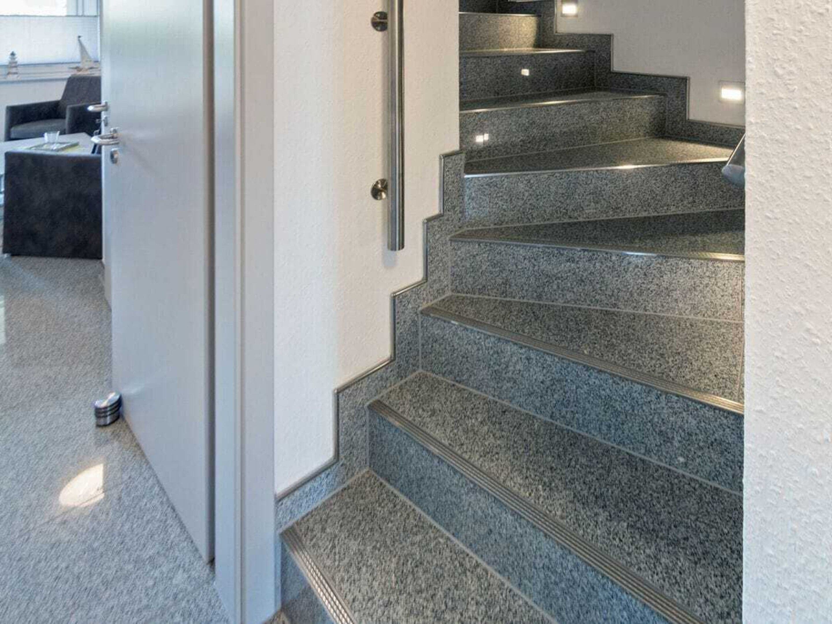 Eine Treppe mit Handlauf und Teppich.