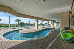 A swimming pool area with lounge chairs and a hot tub. - Oceanfront 3BR- Windy Hill Dunes 705- Lazy River (North Myrtle Beach)