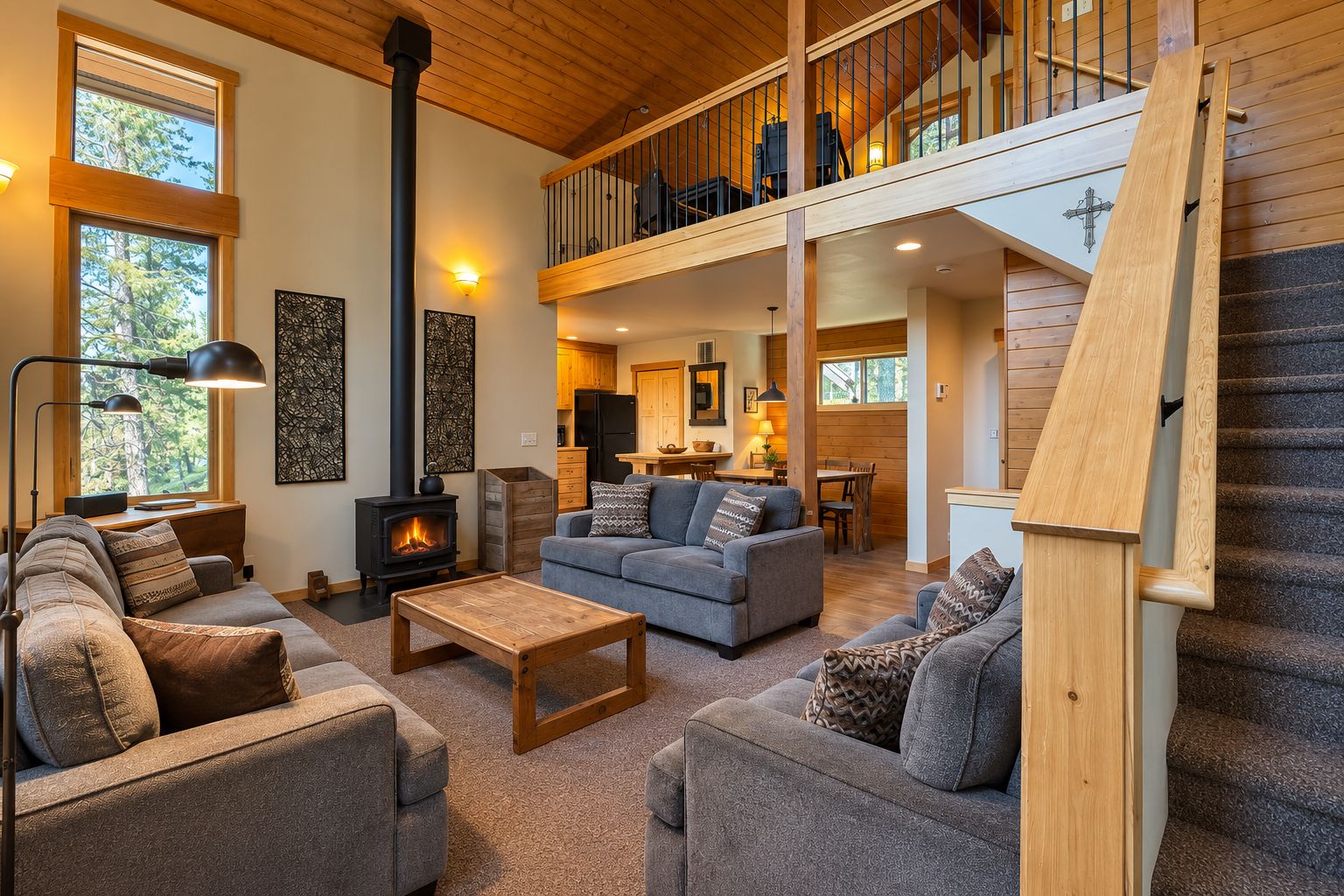 A spacious living area with a fireplace, sofas, and a staircase leading to an upper level.