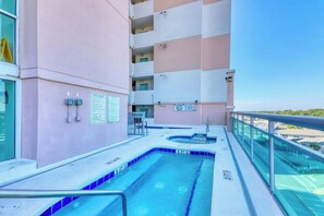 Ein Swimmingpool auf einem Balkon mit blauem Himmel im Hintergrund.