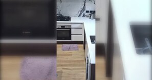 Eine Küche mit einem Backofen von Bosch, einer Mikrowelle und einem Toaster auf der Arbeitsfläche.