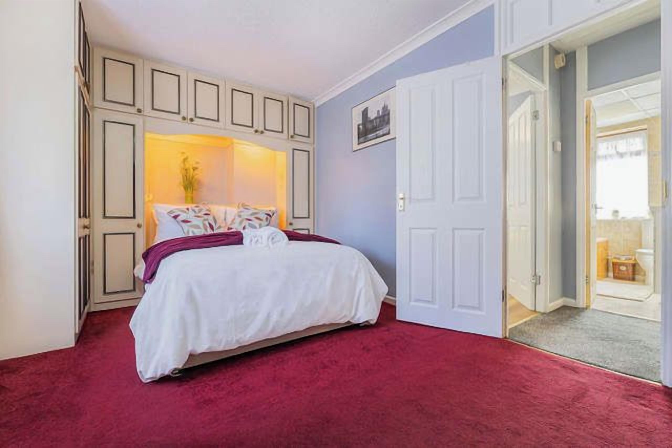 Ein Schlafzimmer mit einem Bett, einer Tür und Blick auf einen Balkon.