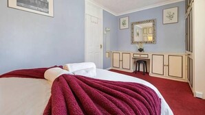 Un dormitorio con cama, cómoda, espejo y puerta.