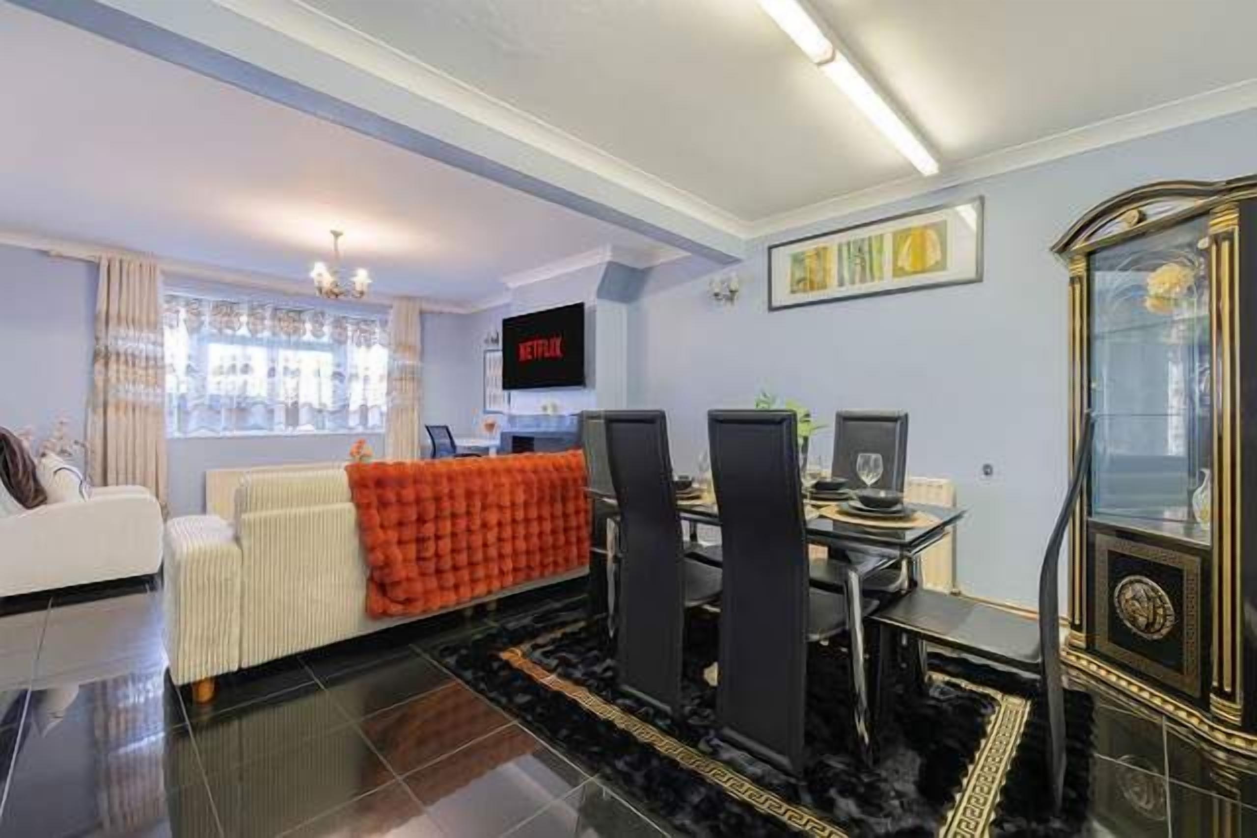 A modern living room with a sofa, a coffee table, a fireplace, and a television.