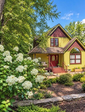 A two-story house with a red door, yellow siding, and a front porch. - The ‘Little House’ in Black Mountain (Black Mountain)