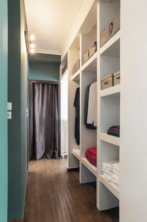 A walk-in closet with multiple shelves, a hanging rod, and a radiator. - Ifigenia and Evrdiki Apts near Acropolis (Athina)