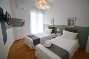 A hotel room with two beds, a bedside table with a lamp, a mirror, and artwork on the walls. - Ifigenia and Evrdiki Apts near Acropolis (Athina)