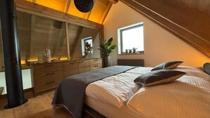 Quarto com cama, cômoda, janela e planta.