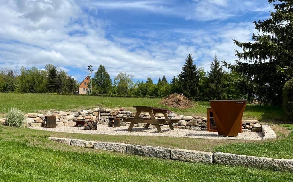 A picnic area with a table and benches, surrounded by rocks and greenery.