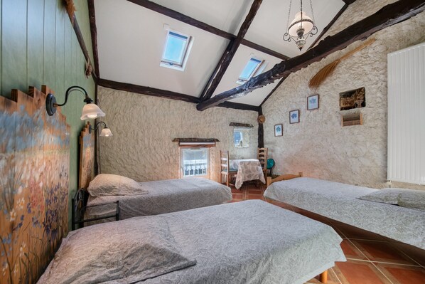 A room with two beds, a dining table, and a chandelier. - Bed and Breakfast 'Chambre - L'herbier' with Shared Terrace, Shared Garden and Wi-Fi (Castillon)
