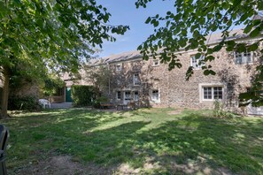A stone building with a grassy yard and a wooden bench. - Bed and Breakfast 'Chambre - La Campagne' with Shared Terrace, Shared Garden and Wi-Fi (Castillon)
