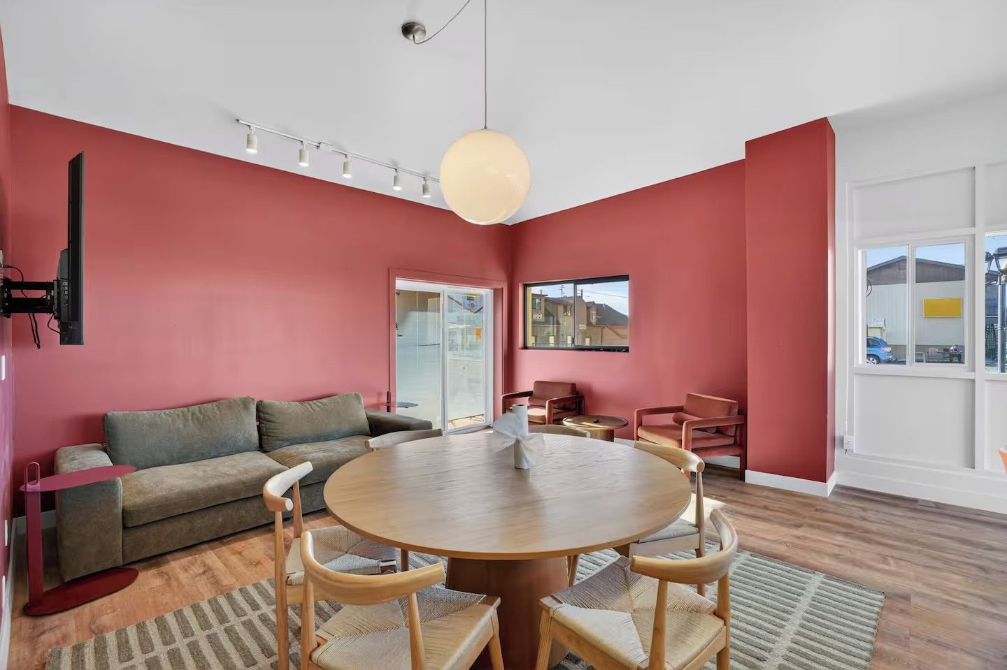 A modern living room with a round wooden table, a sofa, and a television.