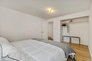 A bedroom with a bed, a wardrobe, and a small seating area. - Relaxing Lynnwood Getaway   Two Beds with Parking (Lynnwood)