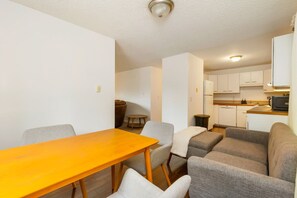 Een knus woongedeelte met eettafel, bank en kitchenette.
