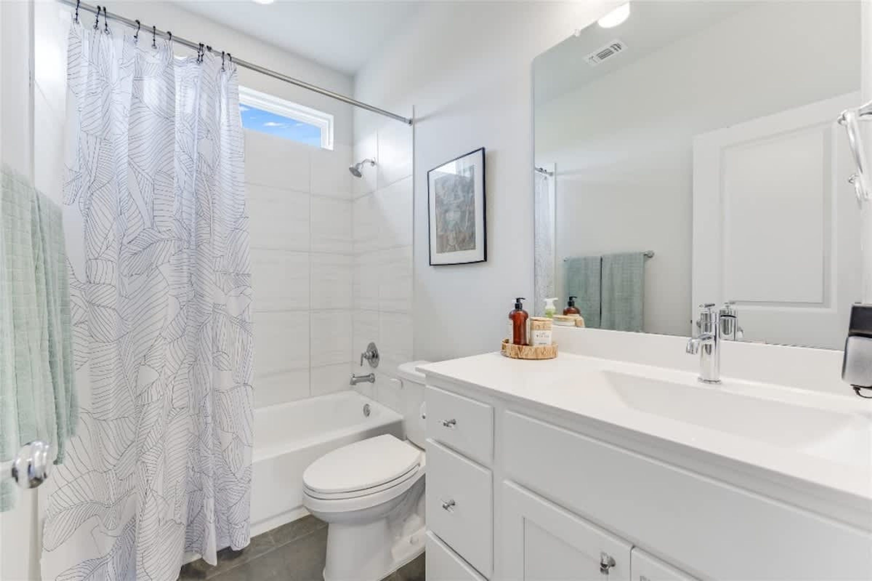 A modern bathroom with a shower, toilet, and vanity.