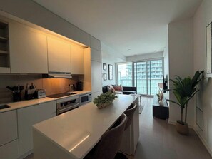 Una cocina moderna con una isla central, electrodomésticos integrados y vistas al exterior.
