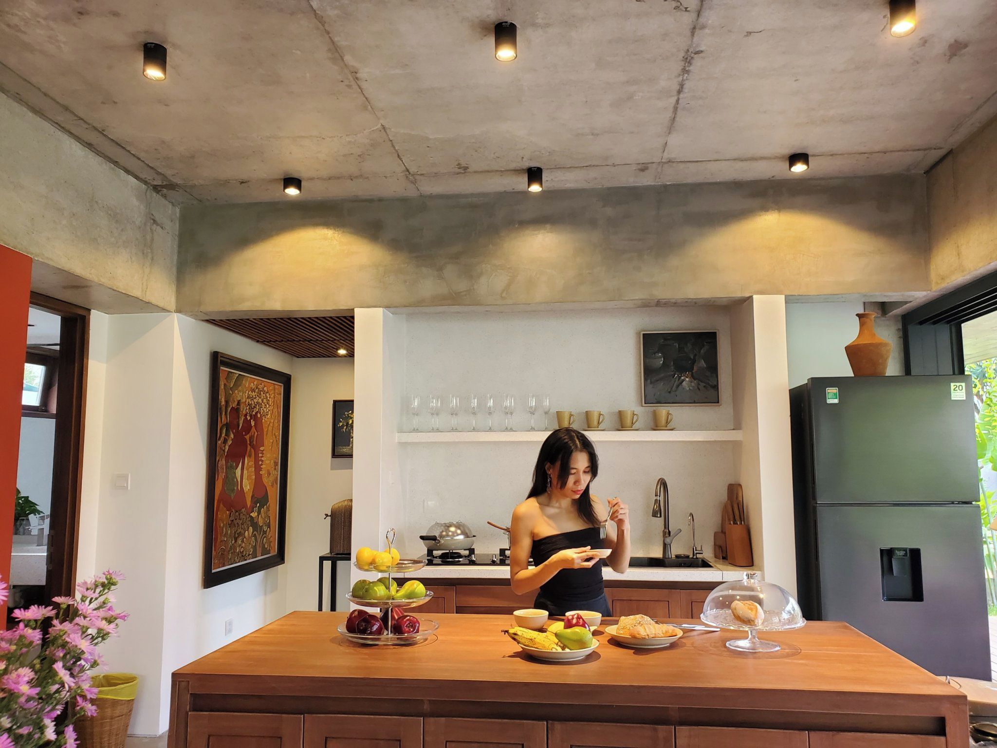 Una cuina moderna amb una illa central, un frigorífic i una finestra.