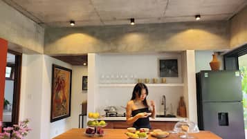 Una cuina moderna amb una illa central, un frigorífic i una finestra.