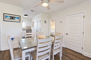 A dining area with a table, chairs, and a ceiling fan. - Ocean-View North Beach Condo with Pools & Community Private Beach Access (Tybee Island)