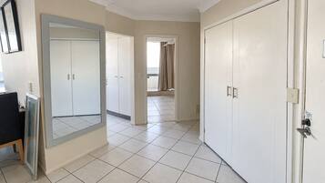 A hotel room with a large mirror, a wardrobe, and a door leading to a balcony.