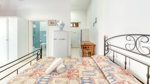A bedroom with a bed, a wardrobe, a desk, and a bathroom visible through an open door. - Apartment 'Le Colonie - Pineta' with Private Terrace and Shared Garden (Presicce)