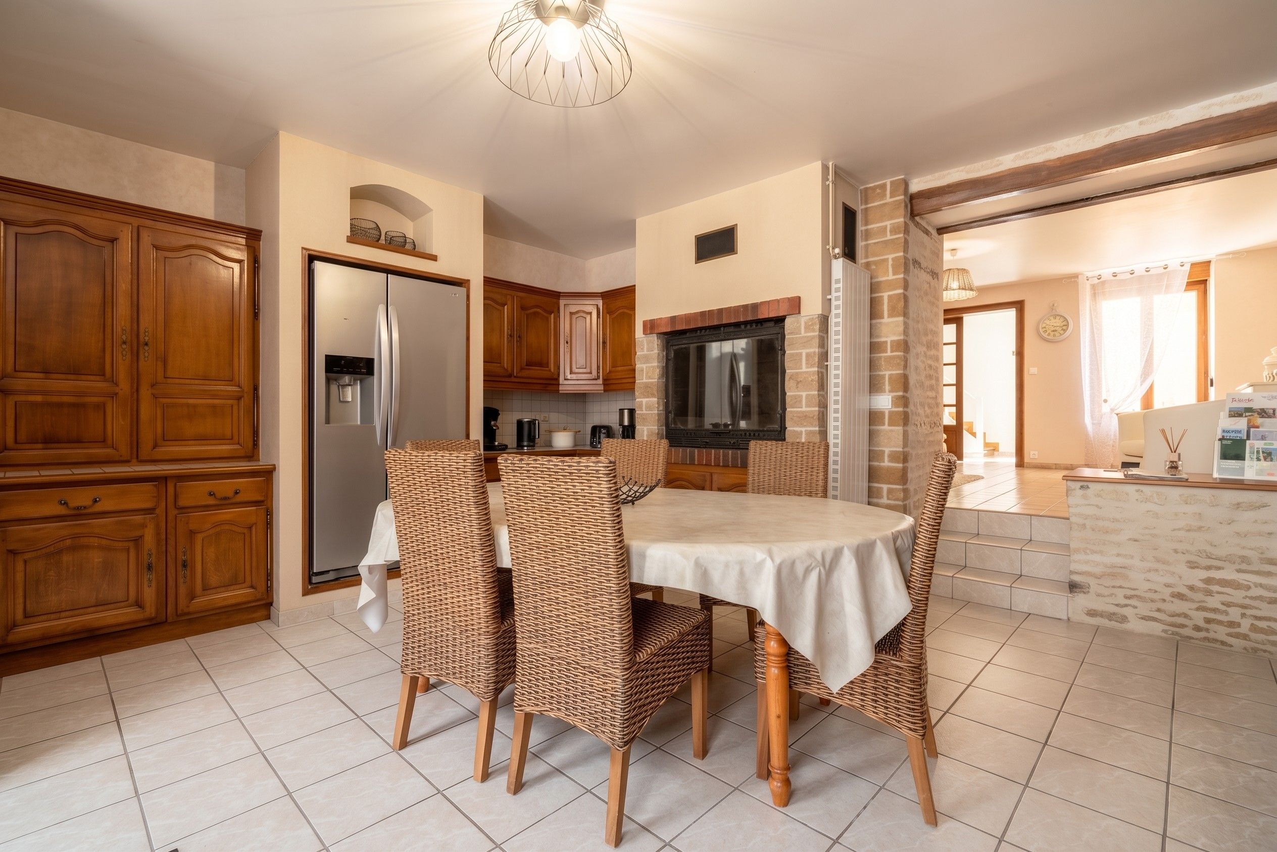 A kitchen with a dining table, chairs, and a refrigerator.