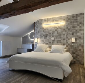 Un dormitorio moderno con una cama curvada, un muro con estampado geométrico y un tragaluz.