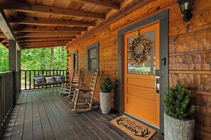A wooden cabin with a porch, a rocking chair, a bench, and a welcome mat. - The Dwell Cabin NEW LISTING DISCOUNT, Screened-In Hot Tub (Sevierville)