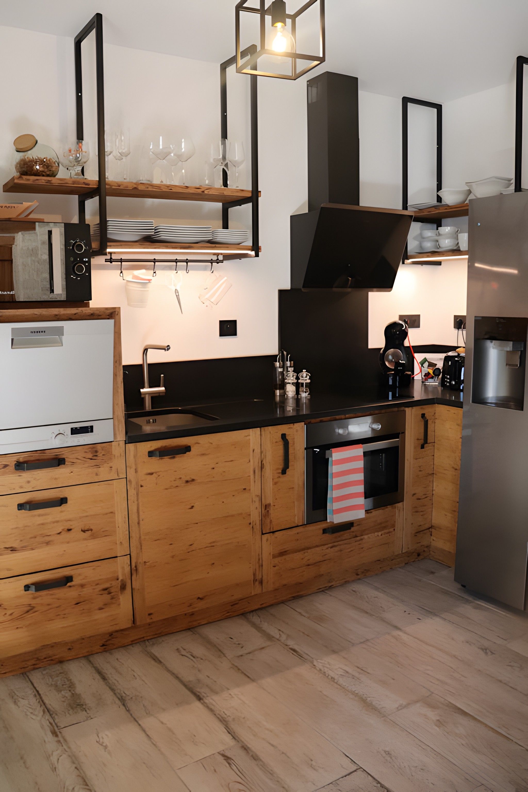 Una cocina moderna con armarios de madera, horno empotrado y refrigerador de acero inoxidable.