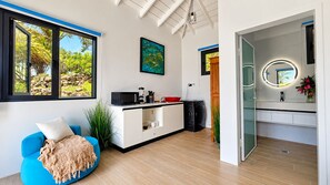A modern kitchen with a microwave, coffee maker, and a red bowl on the counter.
