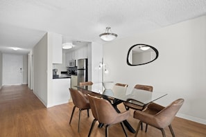 Eine moderne Küche mit weißen Schränken, einer Mikrowelle und einem Kühlschrank.