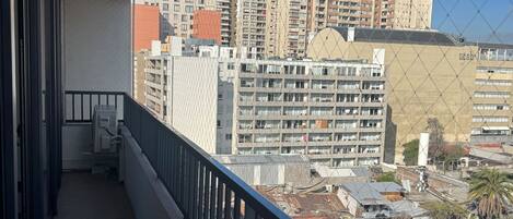 A balcony with a view of high-rise buildings and a clear sky.