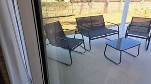 Un patio con una mesa y dos sillas.