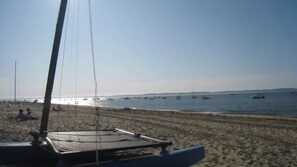 A beach with a sailboat in the foreground and several boats in the water. - Large family villa 50m from the beach (Arcachon)