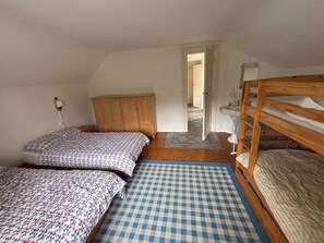 A bedroom with two beds, a wooden wardrobe, a bathroom with a sink, and a door leading to another room. - Large family villa 50m from the beach (Arcachon)