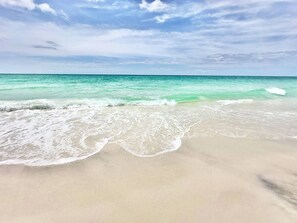 A beach with clear turquoise water and gentle waves. - West End PCB | 1/2 Block to Beach+Heated Pool (Panama City Beach)