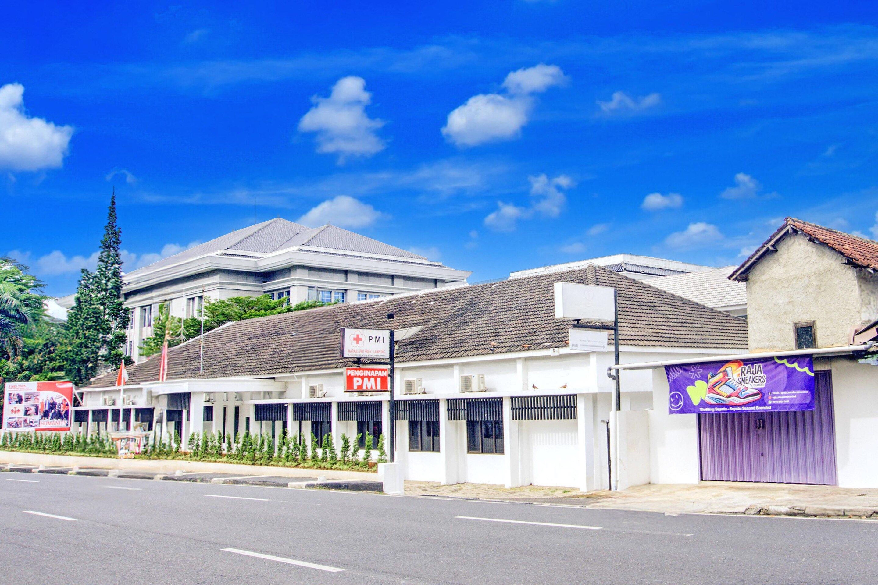 A street view with a building labeled 'PMI' and a sign for 'PENGINAPAN PMI'.