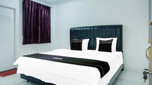 Una habitación de hotel con cama, ventana con cortinas, puerta y suelo de baldosas.