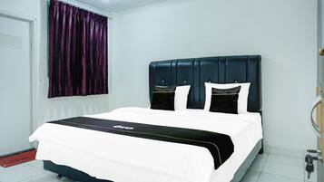 A hotel room with a bed, a window with curtains, a door, and a tiled floor.