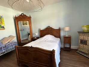 A bedroom with a wooden bed, a nightstand, a dresser, a mirror, and a hanging lamp. - Charming house in Blainville-sur-l'Eau - 6 guests (Blainville-sur-l'Eau)