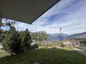 A covered outdoor area with a view of mountains, a wooden fence, and a street lamp. - Montchavin Apartment, Mont Blanc View - 7 guests (La Plagne Montchavin Les Coches)