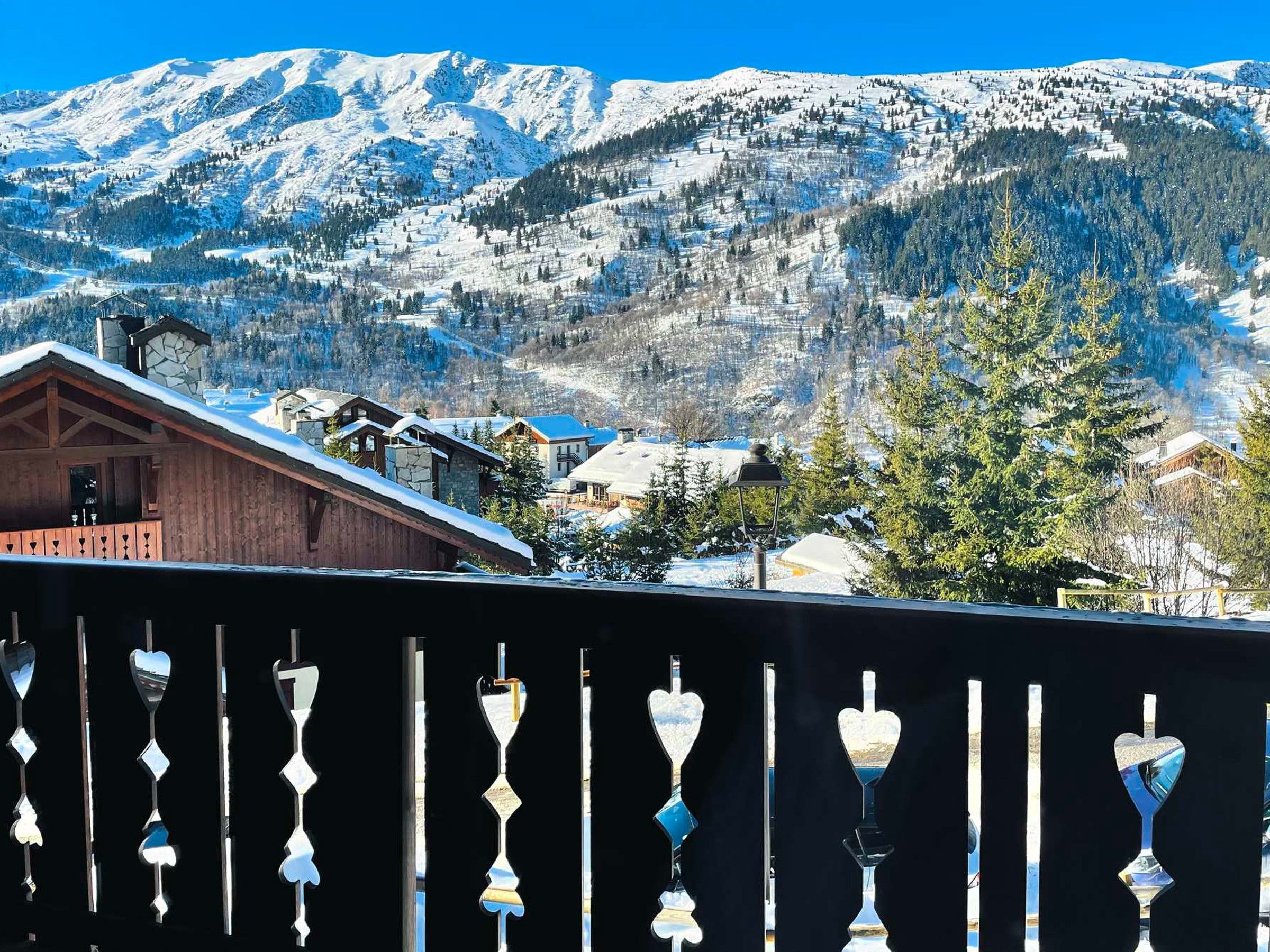 A mountain landscape with snow-covered peaks and a village below.