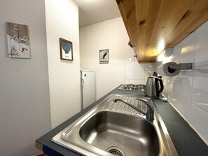 A compact kitchen with a stainless steel sink, a refrigerator, and a coffee maker. - Pleasant apartment, pets allowed - 6 guests (Valfréjus)