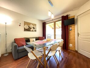 A dining area with a glass table, wooden chairs, a grey sofa, and a wooden ceiling. - Pleasant apartment, pets allowed - 6 guests (Valfréjus)