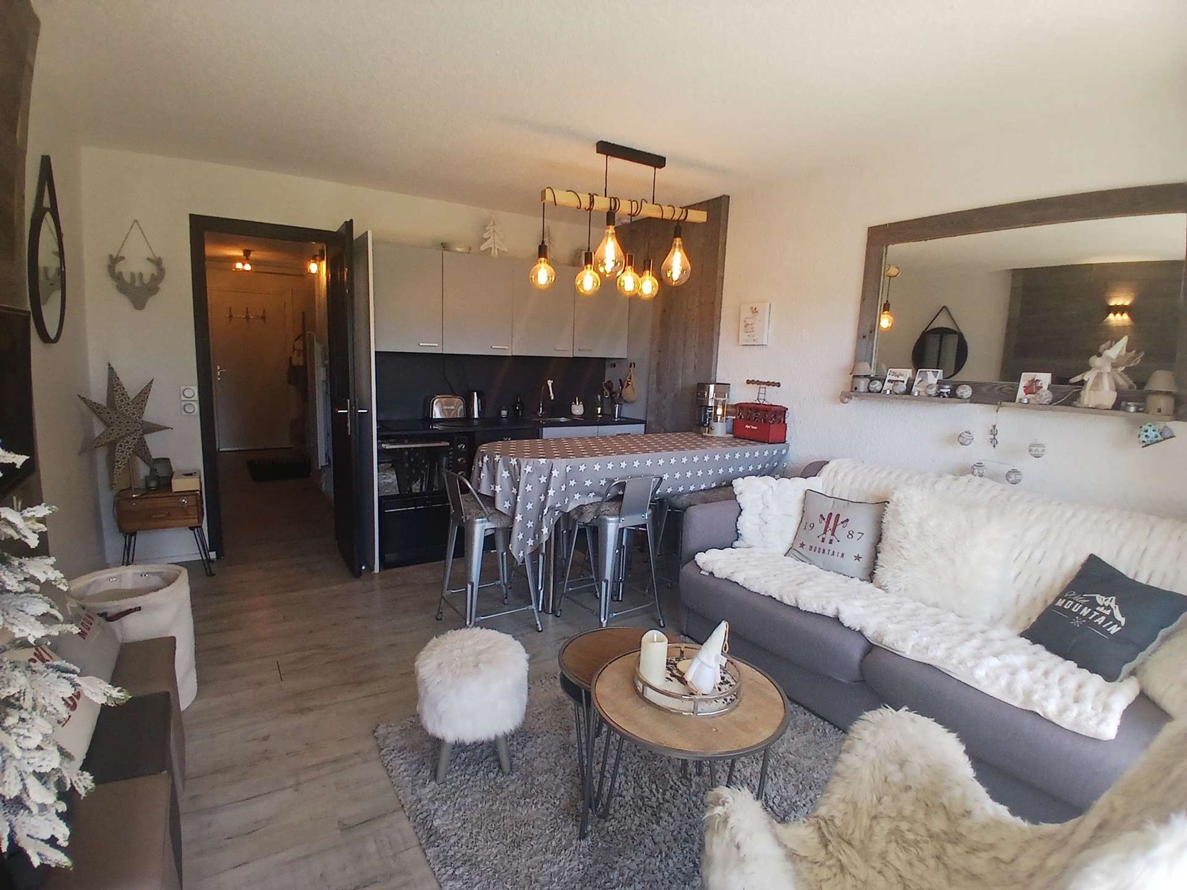 A cozy living room with a sofa, a coffee table, and a dining area with a table and chairs.