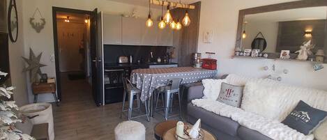 A cozy living room with a sofa, a coffee table, and a dining area with a table and chairs.