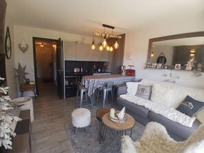 Ein gemütliches Wohnzimmer mit einer Couch, einem Couchtisch und einem Essbereich mit Tisch und Stühlen.